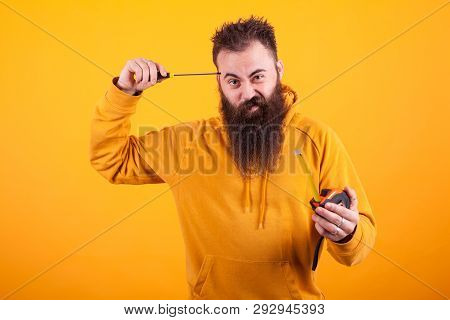 Bearded Architech Holding Roulette And Screwdriver Over Yellow Background