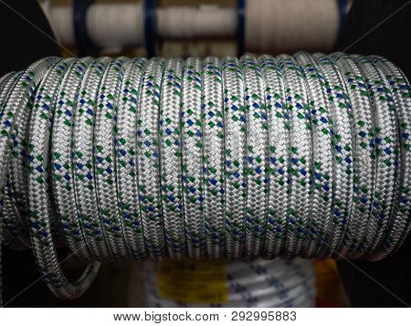 White Rope On A Show-window Of Shop. A Safety Rope For Climbers. The Rope Is Reeled Up On The Coil. 