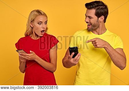 Shocked Funny Young Couple Friends Guy Girl In Casual Clothes Isolated On Yellow Background. People 