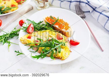 Omelette With Tomatoes, Cheese, Ham And Sandwich Wich Red Cavier On Plate.  Frittata - Italian Omele