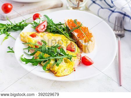 Omelette With Tomatoes, Cheese, Ham And Sandwich Wich Red Cavier On Plate.  Frittata - Italian Omele