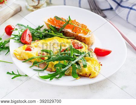 Omelette With Tomatoes, Cheese, Ham And Sandwich Wich Red Cavier On Plate.  Frittata - Italian Omele