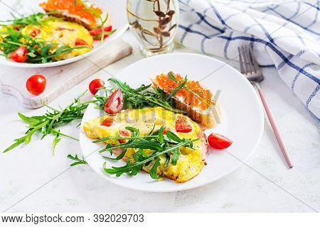 Omelette With Tomatoes, Cheese, Ham And Sandwich Wich Red Cavier On Plate.  Frittata - Italian Omele