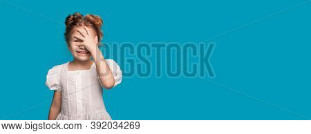 Charming Girl In A White Dress Is Smiling And Touching Her Head With Palm Gesturing Like Forgetting 
