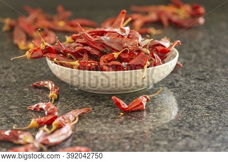 Dried Red Chili Or Chilli Cayenne Pepper In Grey Bawl On Black Marble Background, Close Up