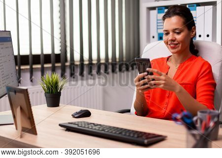 Manage Businesswoman Holding Smartphone Texting Professional Message Sitting At Desk Wearing Red. Pr