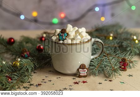 A Gingerman In A Mug With Hot Cocoa And Marshmallow. Christmas Holiday Decorations And Blurred Xmas 