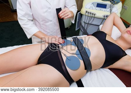Myostimulation Electrodes Are Installed On The Abdominal Muscles Of A Young Woman. A Slender Woman U