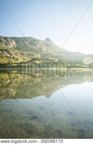 Scenic Bettmer Lake Near Fiesch In Wallis, Switzerland. Reflection On The Lake At Sunrise