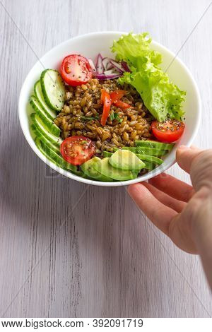 Bowl With Spelt Or Farro, Tomatoes, Cucumbers, Avocado And Onion With Salad Leaves, Herbs And Chia S