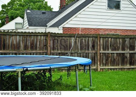 Dangerous Live Downed Power Line Draped Across Fence And Trampoline