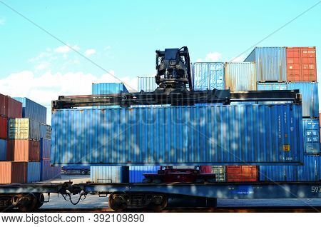 Shipping Container Loading By Richtracker On The Freight Rail Car At Logistic Warehouse Port. Ocean 