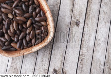 Bowl Of Brazilian Baru Nuts Over Wooden Table With Room For Text.