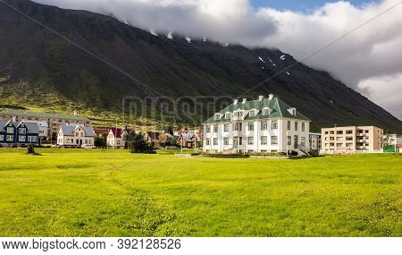 Isafjordur, Iceland - July 7, 2014: White Isafjordur Culture House On A Green Meadow At Sunny Day Wi