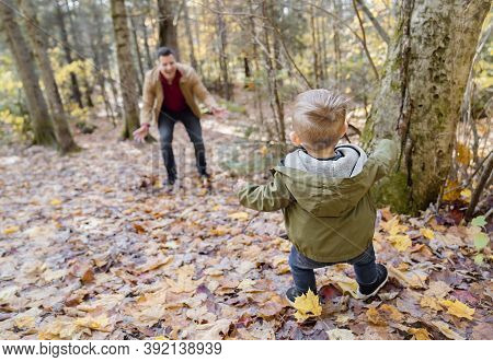 Son And Her Father In The Autumn Season In Park Play Hideout