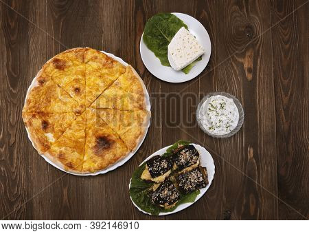 Baked Homemade Cheese Pie, Cheese, Cheese Sauce And Eggplant Salad On Wooden Background. Bulgarian B
