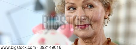 Close-up Of Attractive Elderly Woman Holding Piggy Bank For Money. Colourful Container For Coins And