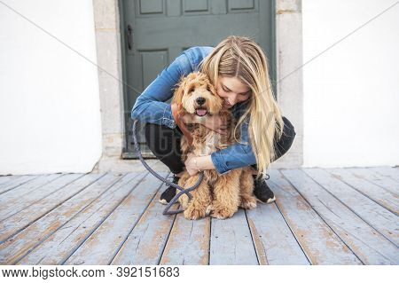 Labradoodle Dog And Woman Outside On Balcony