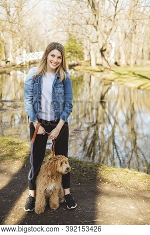 Happy Labradoodle Dog And Woman Outside At The Park