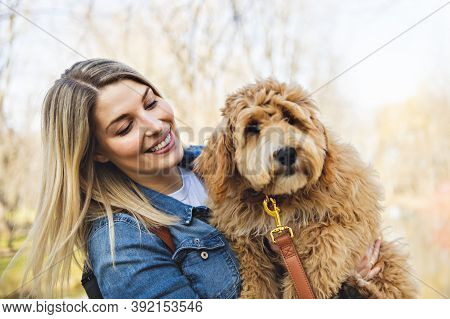 Happy Labradoodle Dog And Woman Outside At The Park