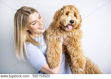 Woman With His Golden Labradoodle Dog Isolated On White Background