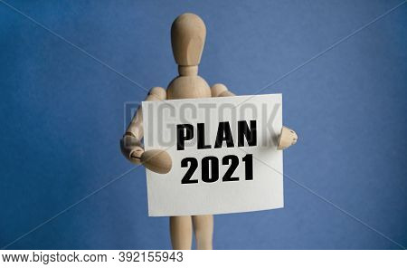 The Wooden Man Holds A White Sign With The Text Plan 2021 In His Hands. The Content Of The Lettering