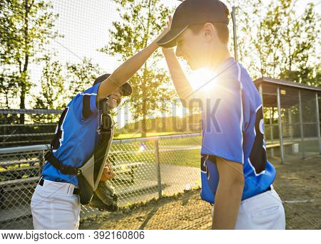 Two Childrens Baseball Players Standing Together On The Playground