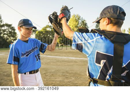 Two Childrens Baseball Players Standing Together On The Playground