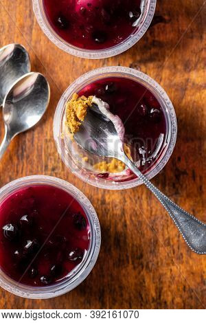 Sweet desssert. Cheesecake cup on wooden table. Top view.