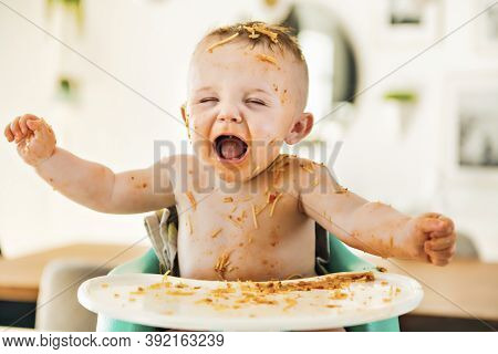 Little Baby Boy Eating Her Dinner And Making A Mess