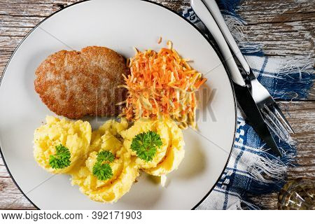 Homemade Minced Meat Cutlet Served With Mashed Potatoes And Carrot Salad.