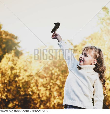 Playful Cute Little Girl Sitting Ohn Fence And Having Fun