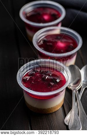 Sweet desssert. Cheesecake cup on black wooden table.
