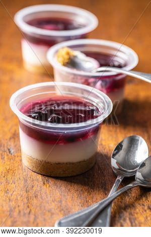 Sweet desssert. Cheesecake cup on wooden table.