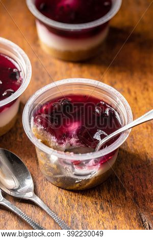Sweet desssert. Cheesecake cup on wooden table.