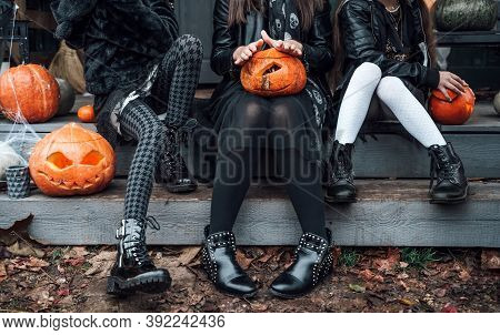 Scary Girls, Sisters, Friends Celebrating Halloween.treak Or Treat Game.pumpkins.sitting On Porch St