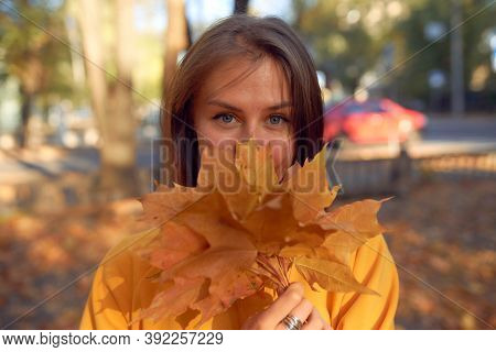 Beautiful Caucasian Young Woman Walking And Having Fun Outdoors In Autumn Time. Bright Yeallow Color