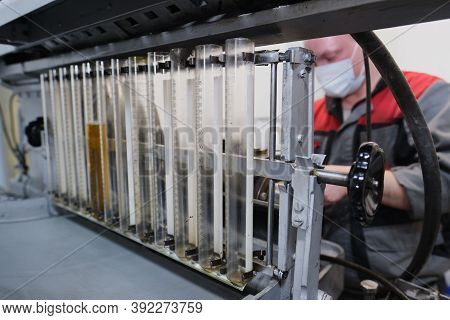 Test Bench For Checking The Injection Pump Of An Industrial Diesel Engine. Glass Flasks With Diesel