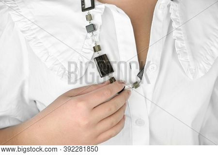 Necklace Acsessorie On A Female Neck. Young Woman Showing Her Necklace On White Shirt. Minimal Style
