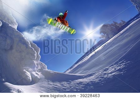 Snowboarder springer mod blå himmel