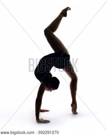 Graceful Female Gymnast In Sportswear Performs A Handstand. Training, Element Of Gymnastics, Acrobat