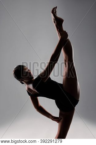 A Flexible Young Female Gymnast In Sportswear Performs A Stretch. Training, Gymnastics, Acrobatics O