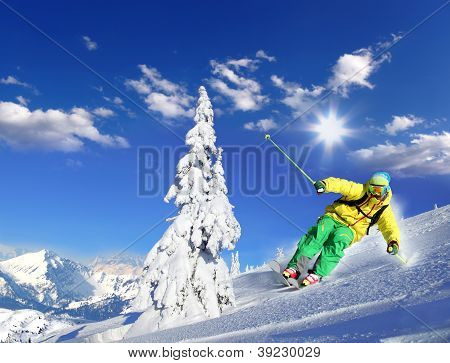 Skier skiing downhill in high mountains