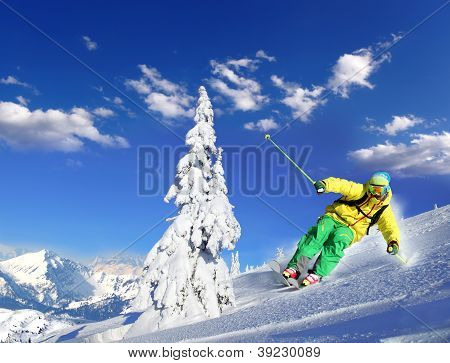 Skier skiing downhill in high mountains