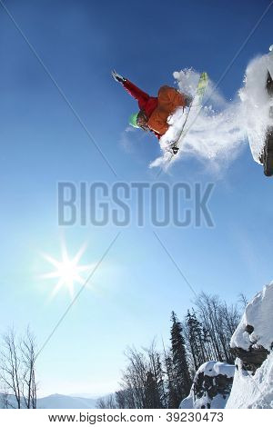 Snowboarder springer mod blå himmel