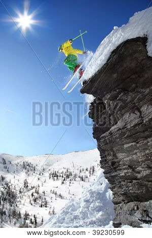 Skier jumping against blue sky from the rock