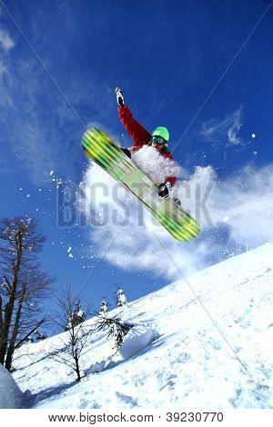 Snowboarder jumping against blue sky