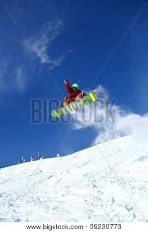 Snowboarder springer mod blå himmel