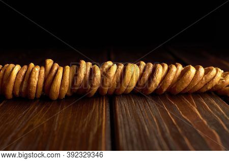 Small Wheat Bagels On A Rope On Dark Wooden Table. Traditional Russian Food. Copy Space.