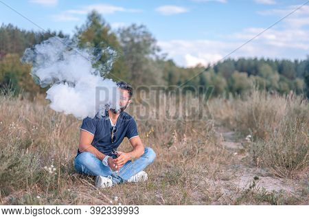 Stylish Brutal Vaper Enjoying An Vape On The Ground. Vaping Concept.
